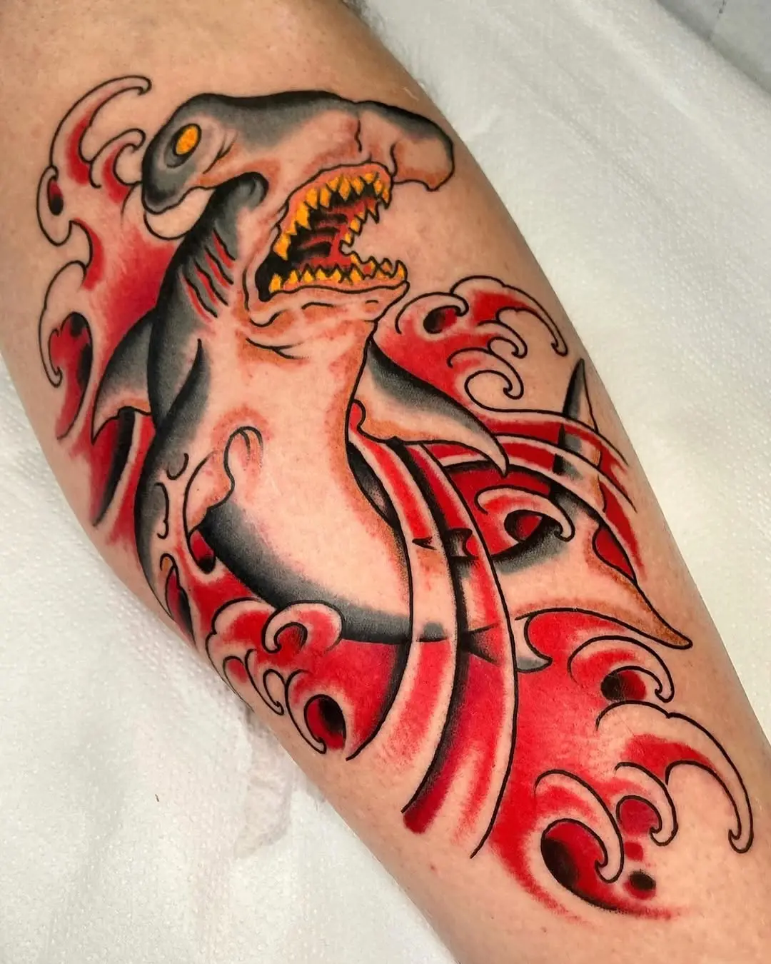 Bold shark tattoo with dramatic wave details