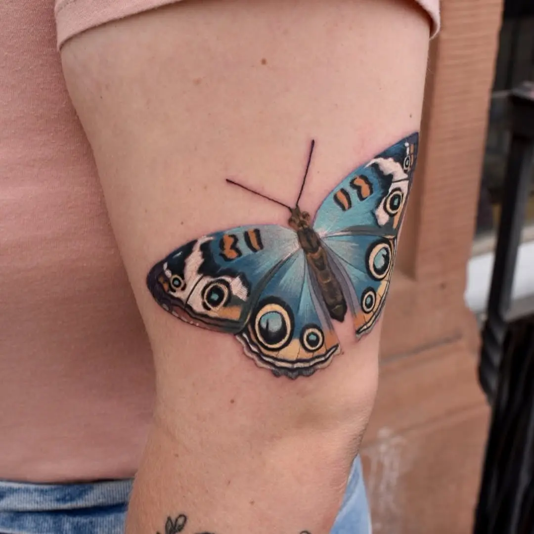 Intricate blue butterfly tattoo on the arm