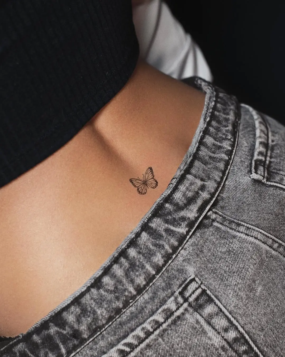 Elegantly understated butterfly waist tattoo design