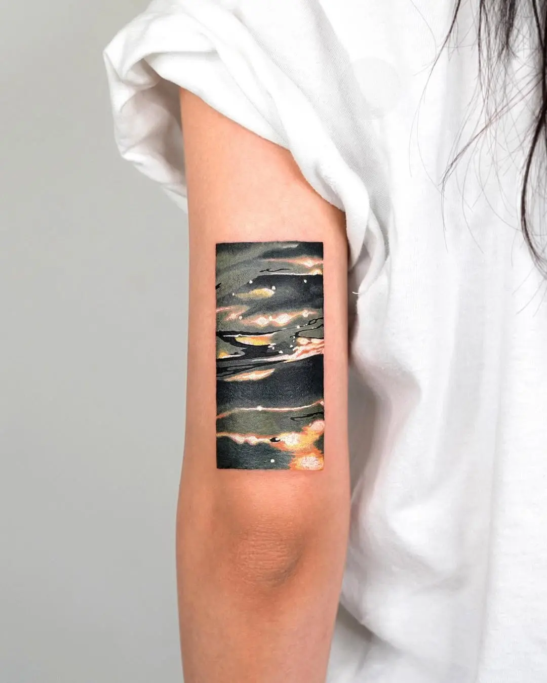 Artistic water illusion tattoo on forearm