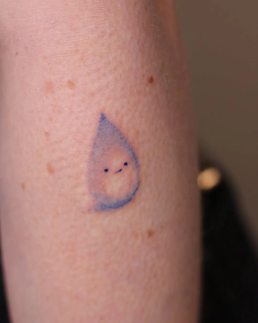 Charming water drop tattoo with a smile