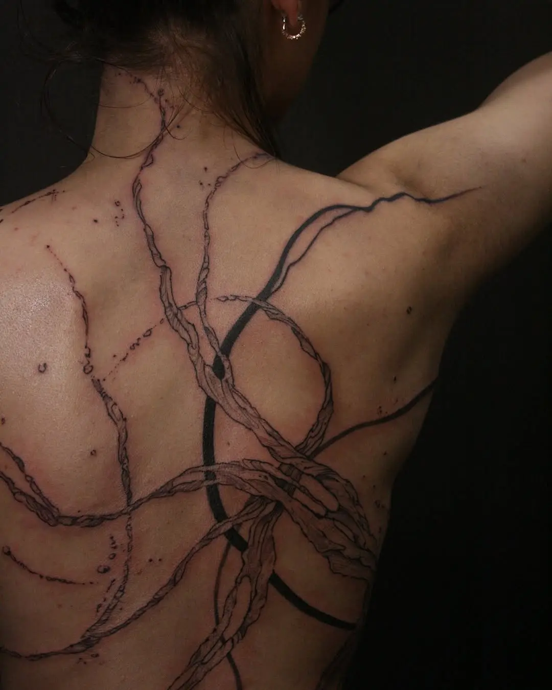 Intricate water-inspired tattoo on the back