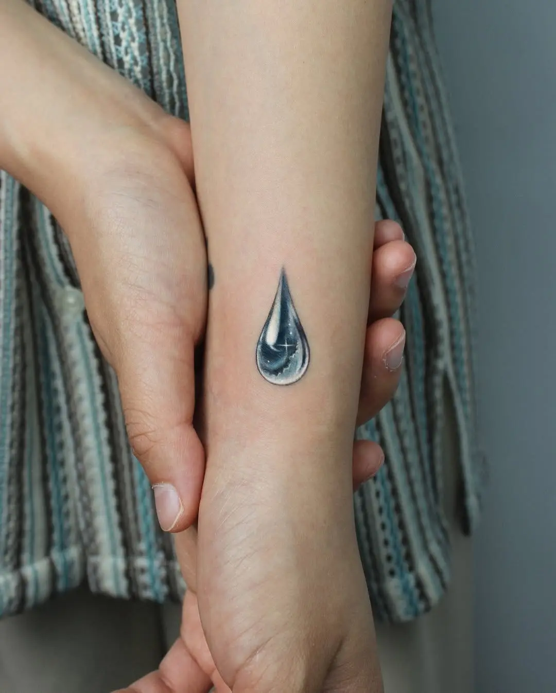 Elegant Water Drop Tattoo on the Arm