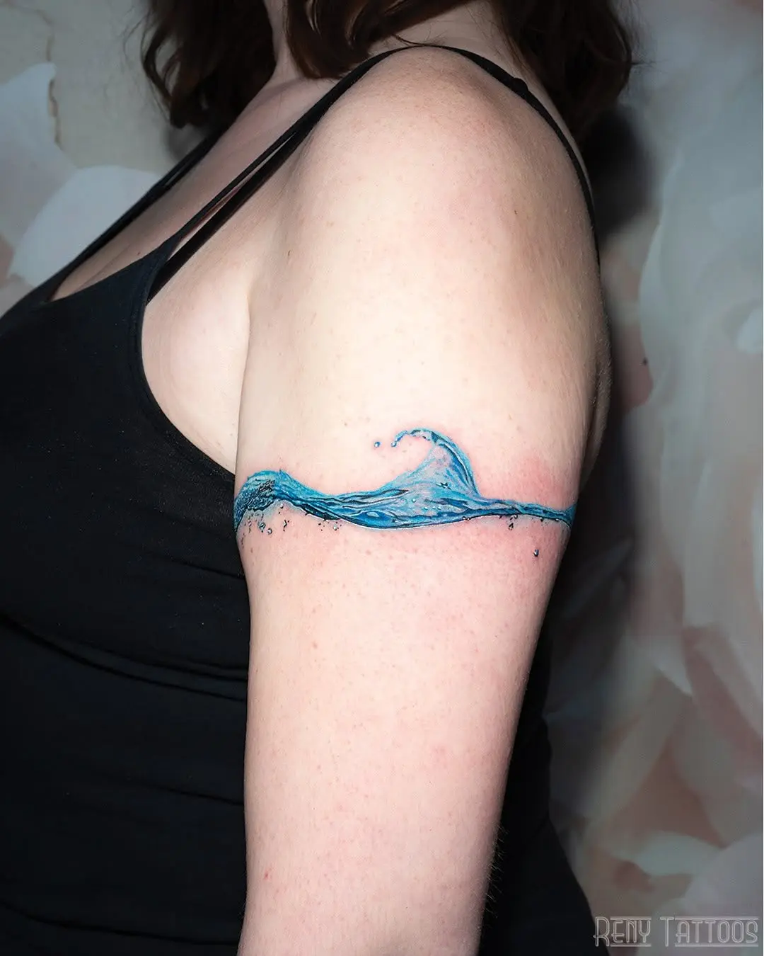 Elegant wave tattoo on the upper arm