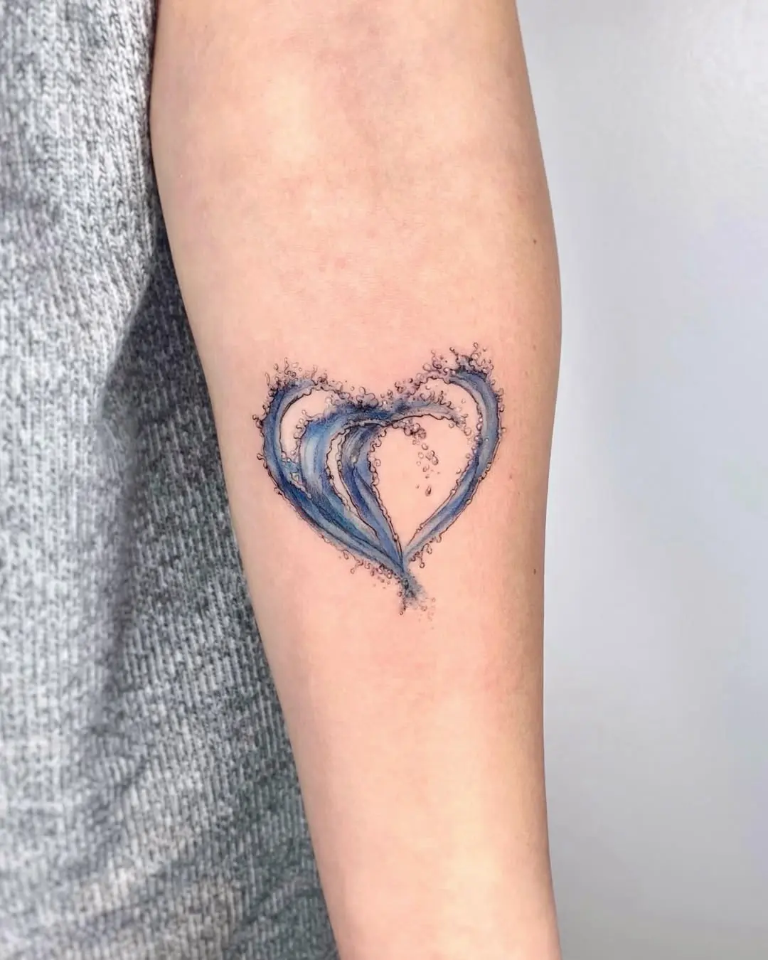 Flowing waves create a heart-shaped tattoo