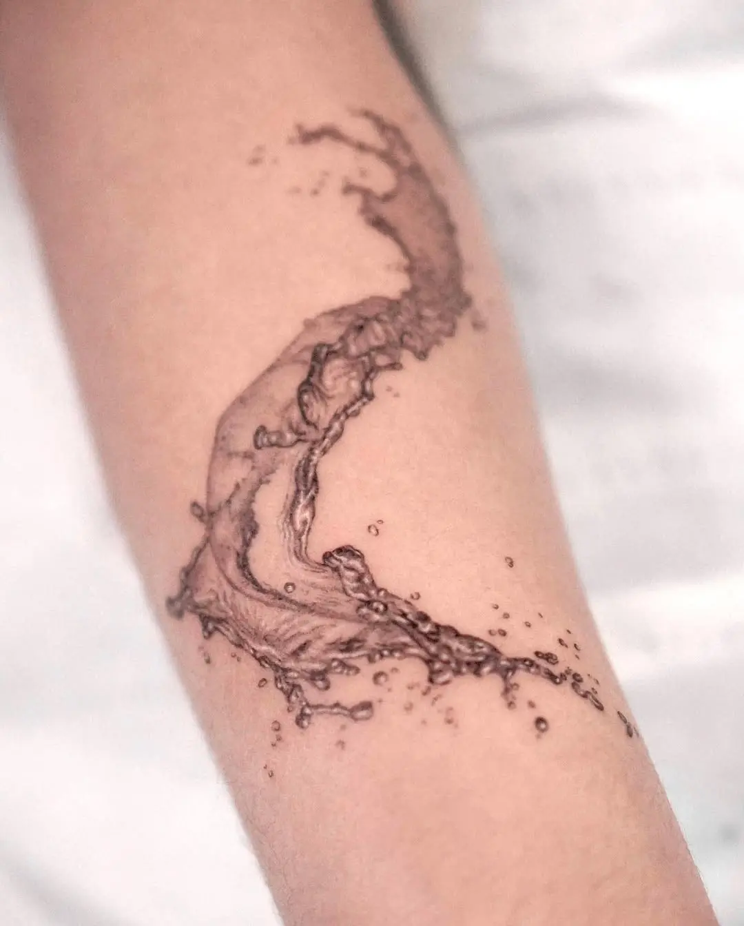 Flowing water tattoo capturing nature's beauty