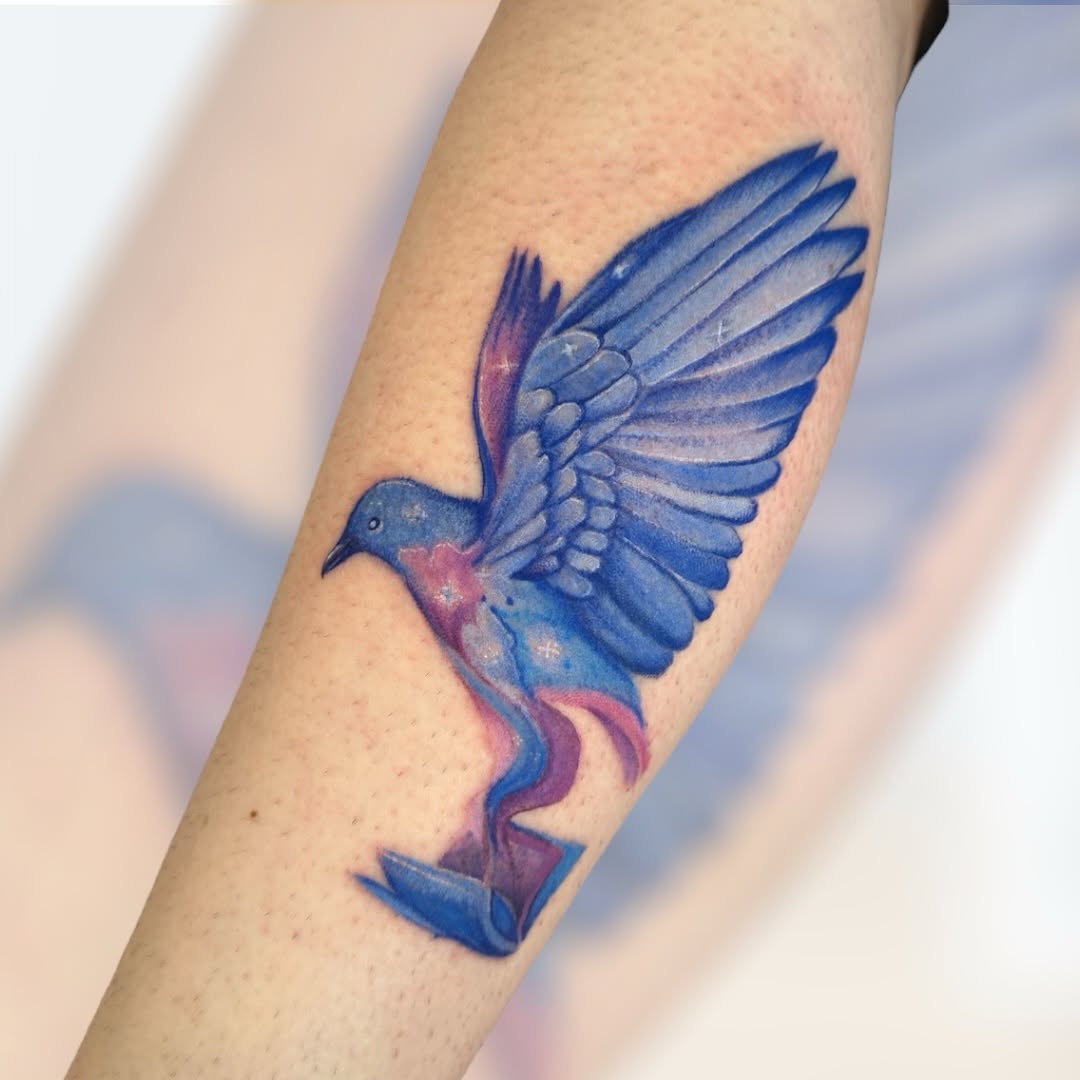 Vivid watercolor bird tattoo showcasing artistic flair