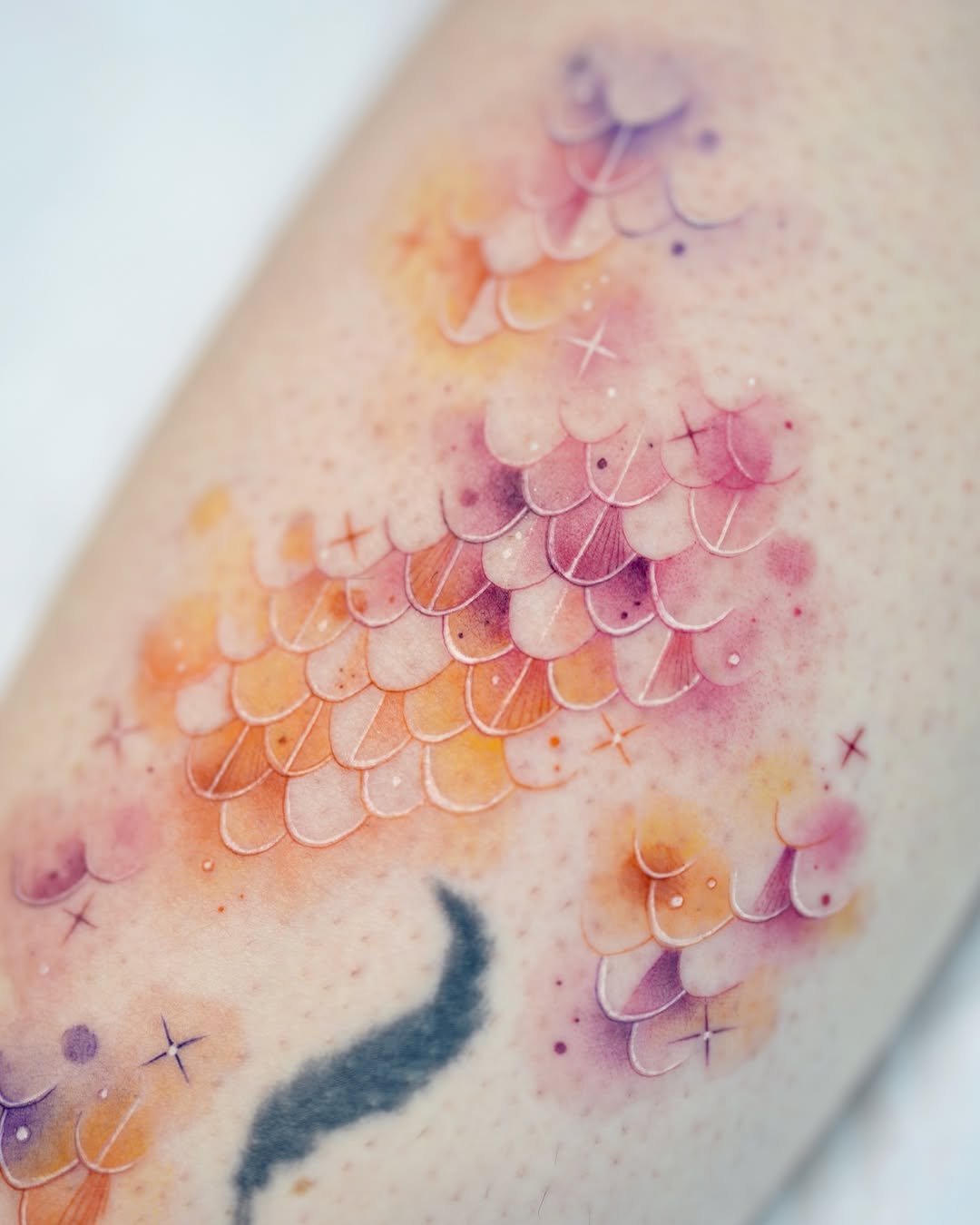 Vibrant watercolor fish scale tattoo design