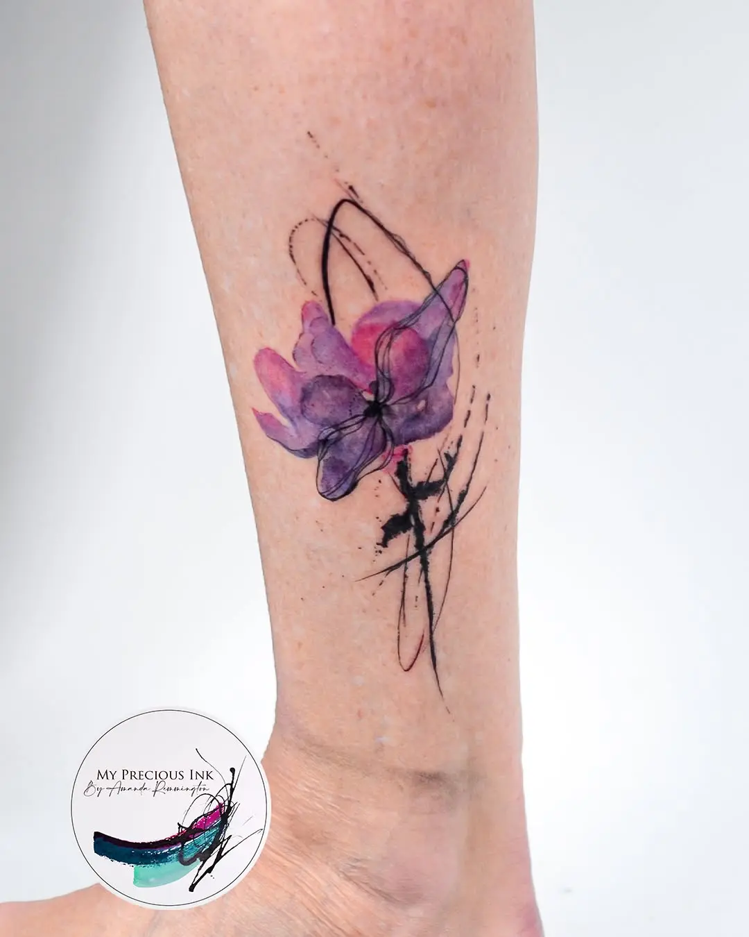 Vibrant floral watercolor tattoo on ankle