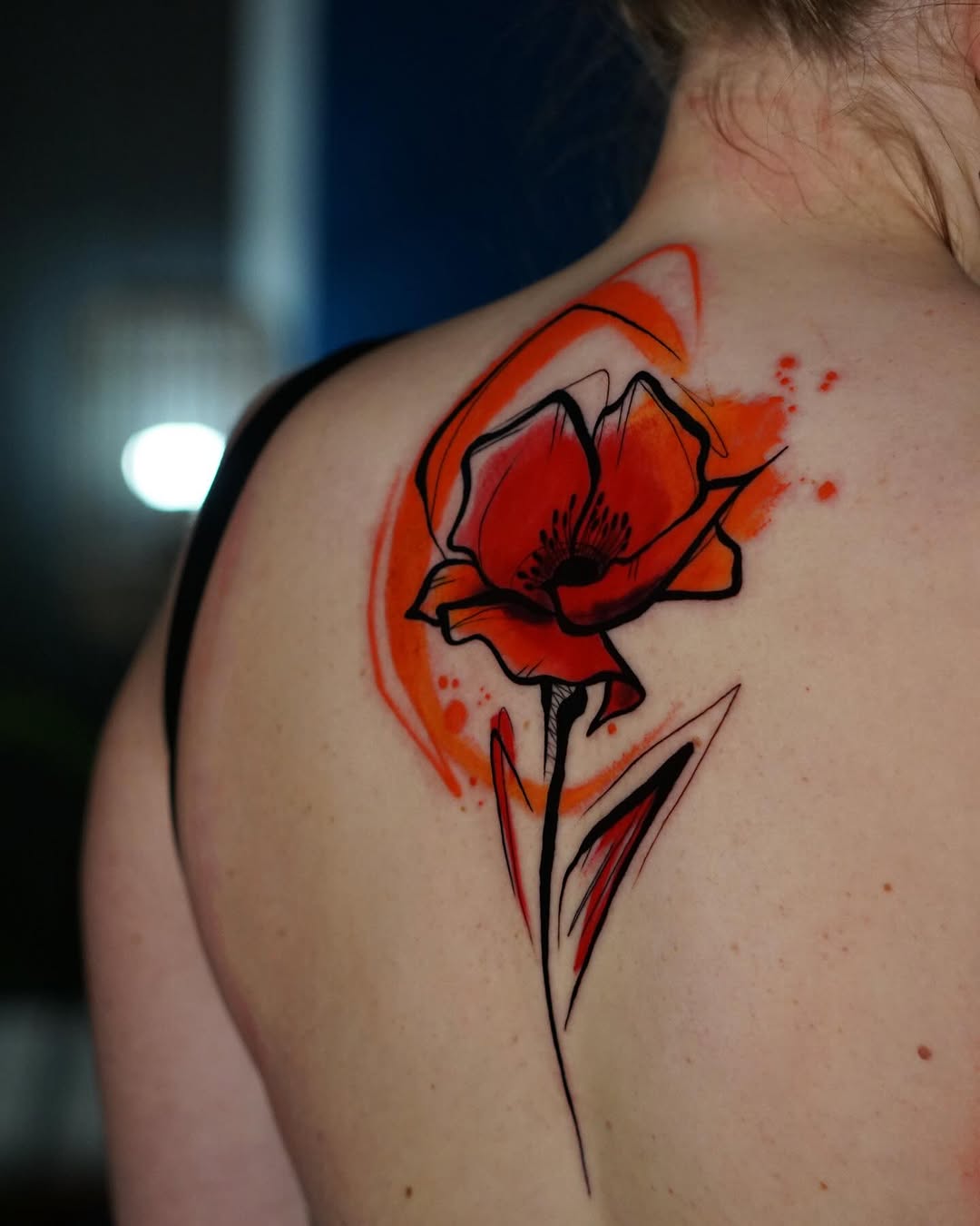 Vibrant watercolor flower tattoo on the back