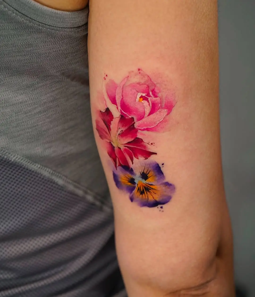 Vibrant floral watercolor tattoo on arm