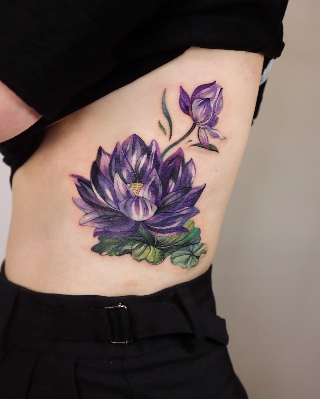 Vibrant watercolor lotus tattoo on the body