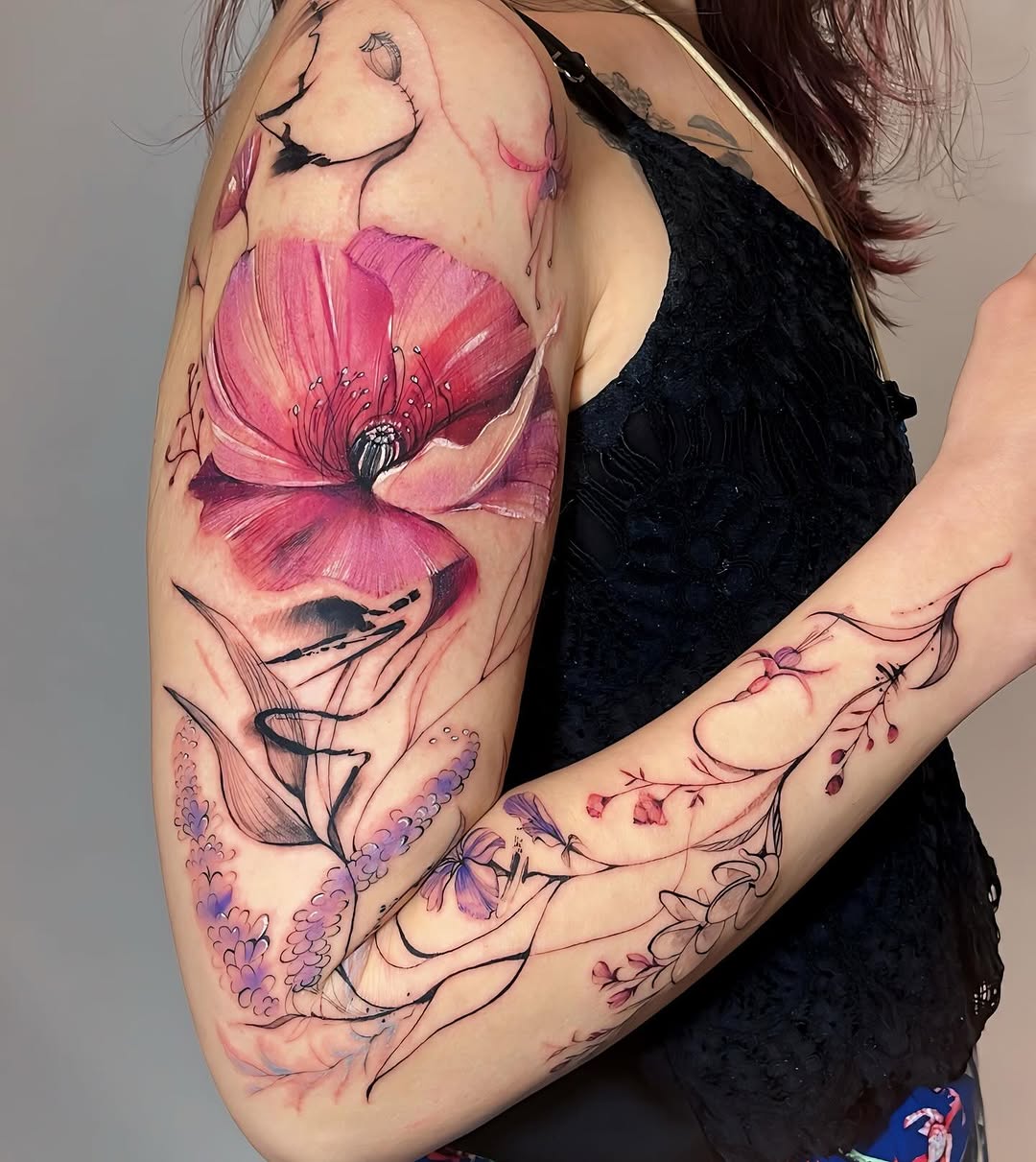 Vibrant floral watercolor tattoo on arm