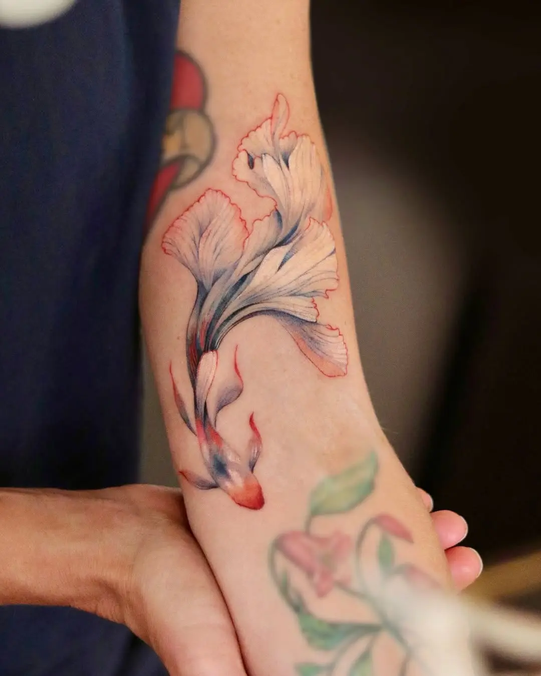 Stunning watercolor goldfish tattoo on the arm