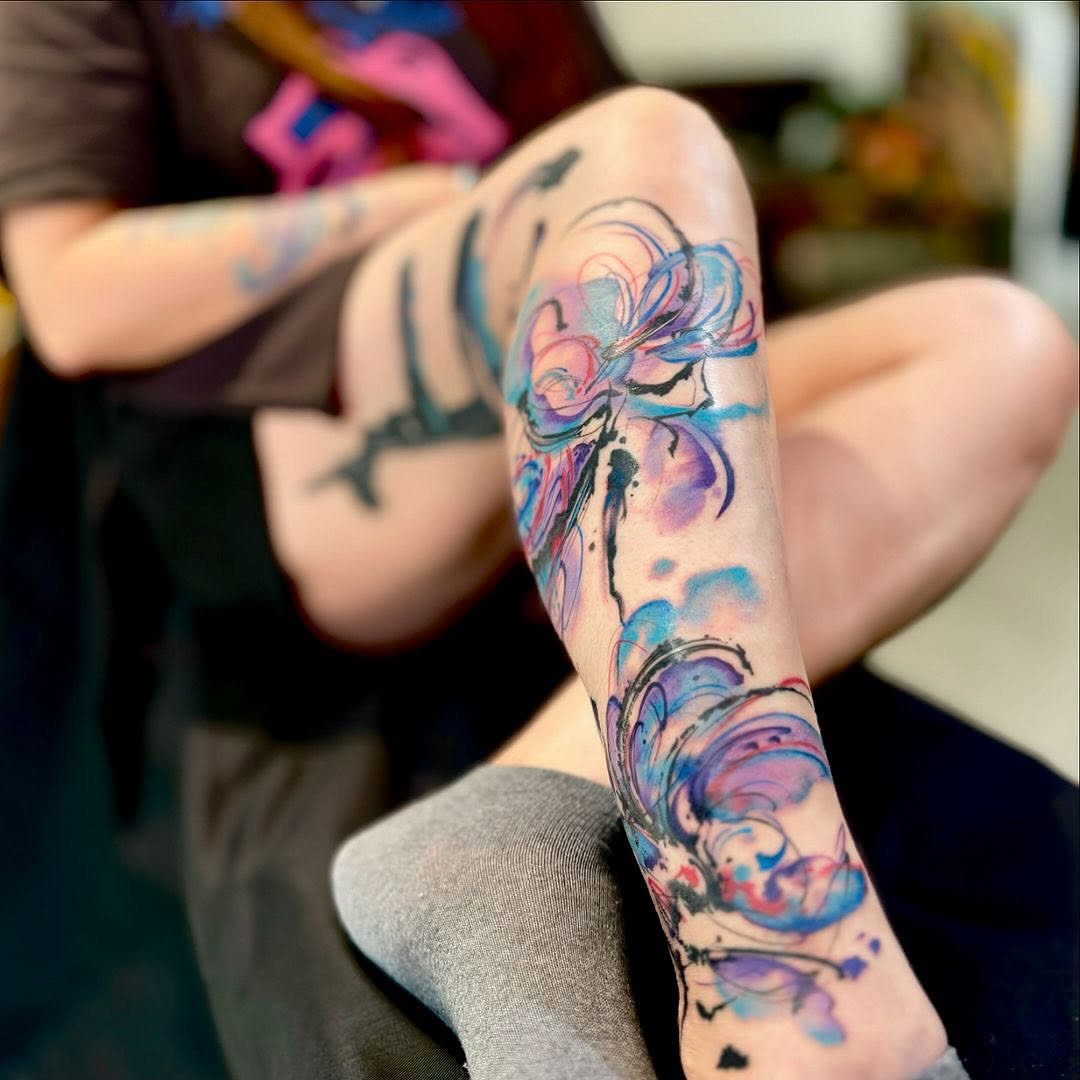 Elegant floral watercolor tattoo on leg