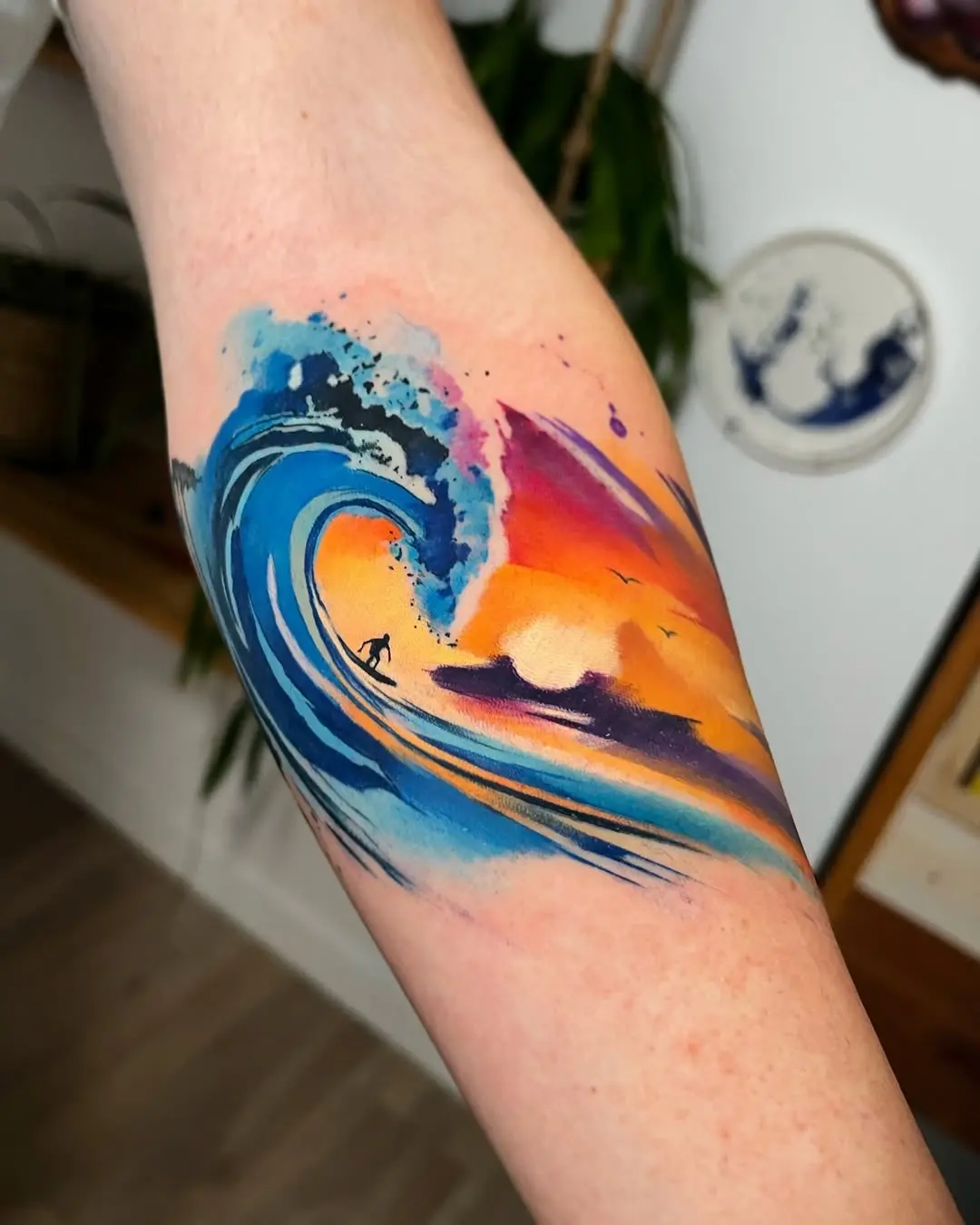 Vibrant wave tattoo with surfer silhouette