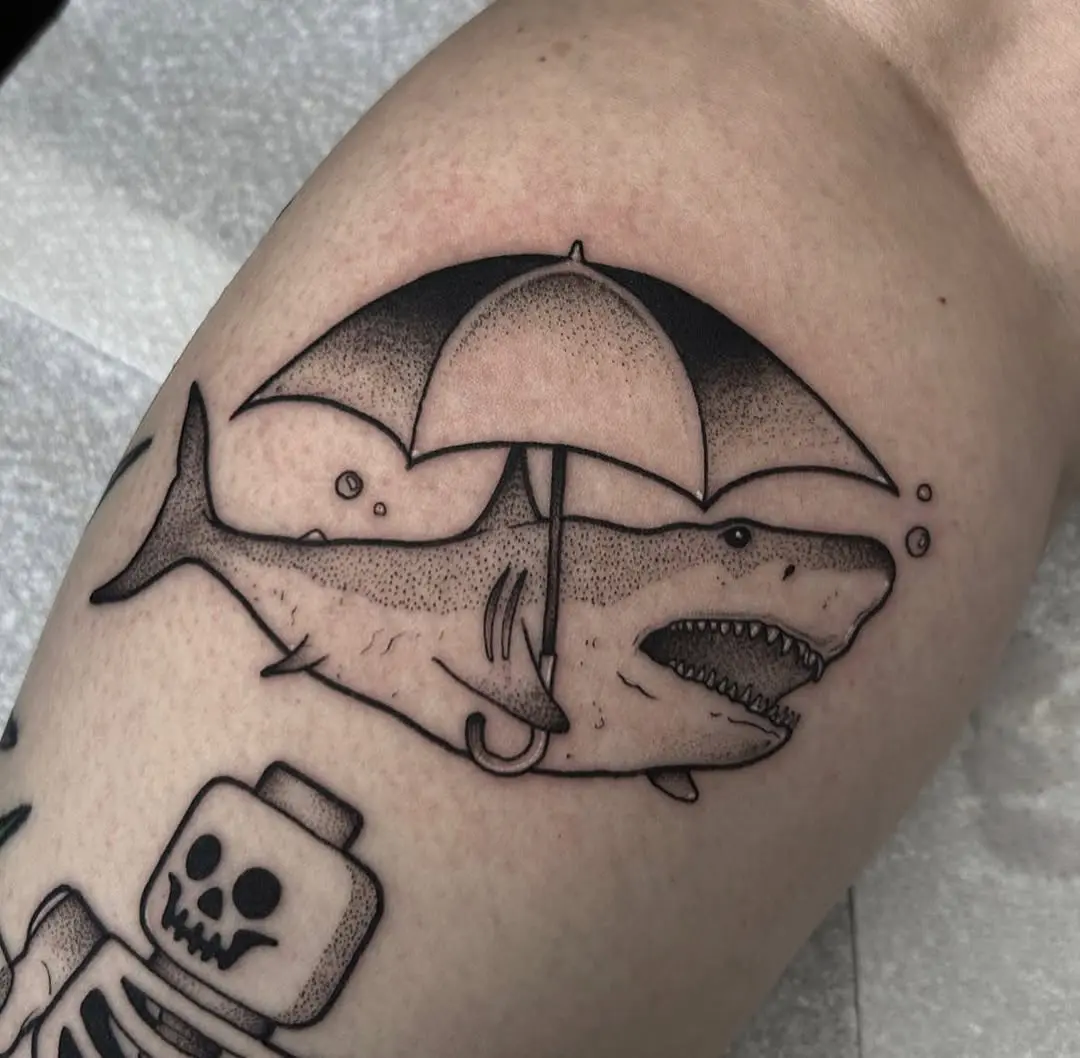 Playful shark tattoo with an umbrella twist