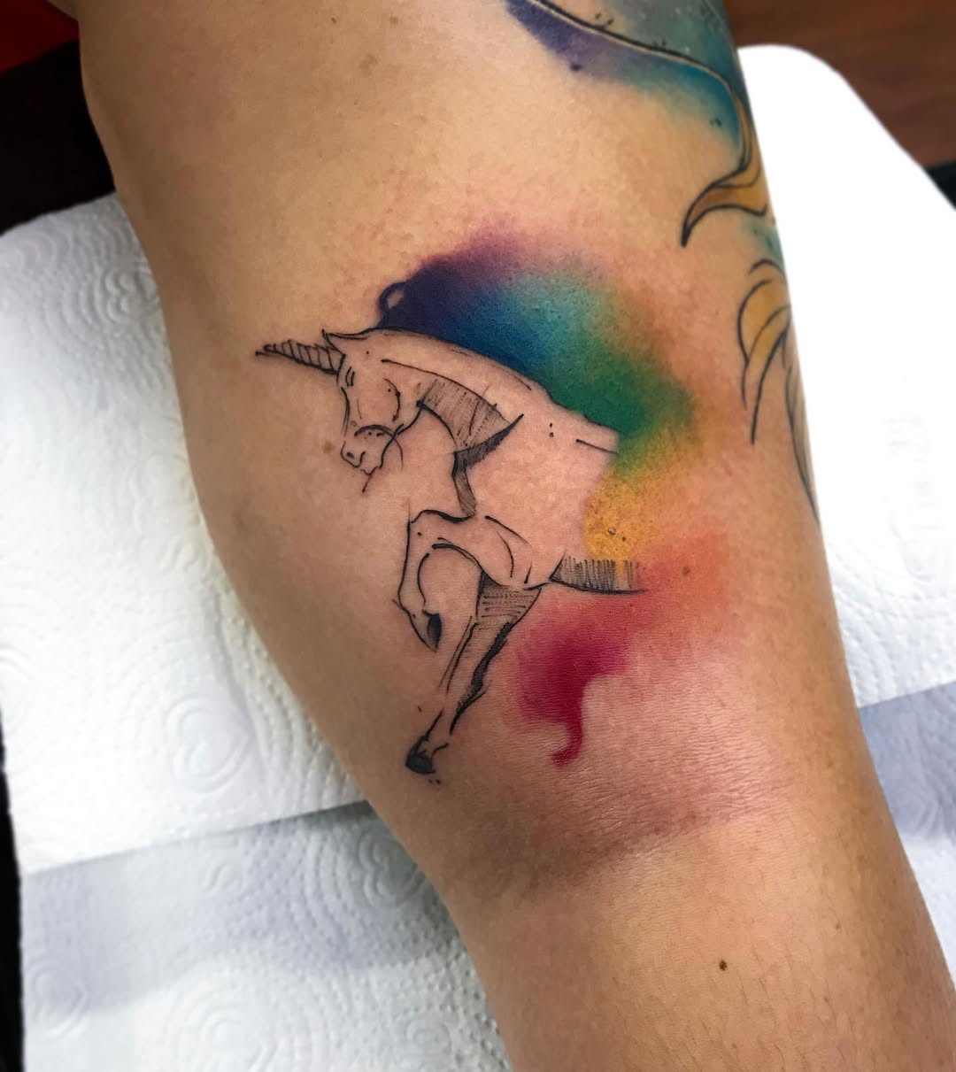 Magical unicorn tattoo with colorful splash