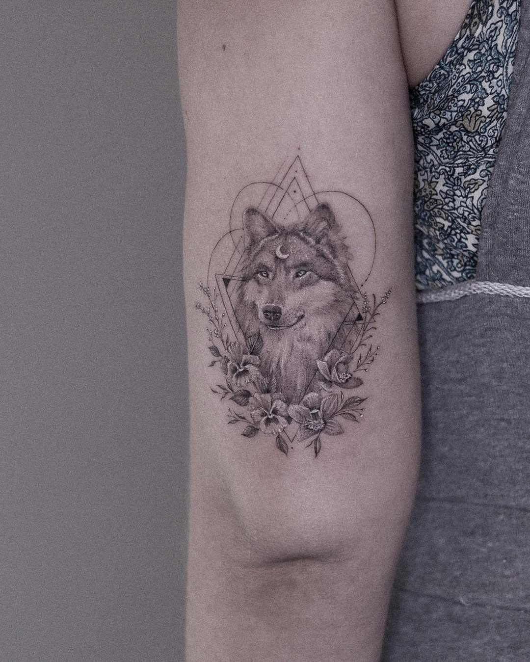 Stunning wolf tattoo with floral elements