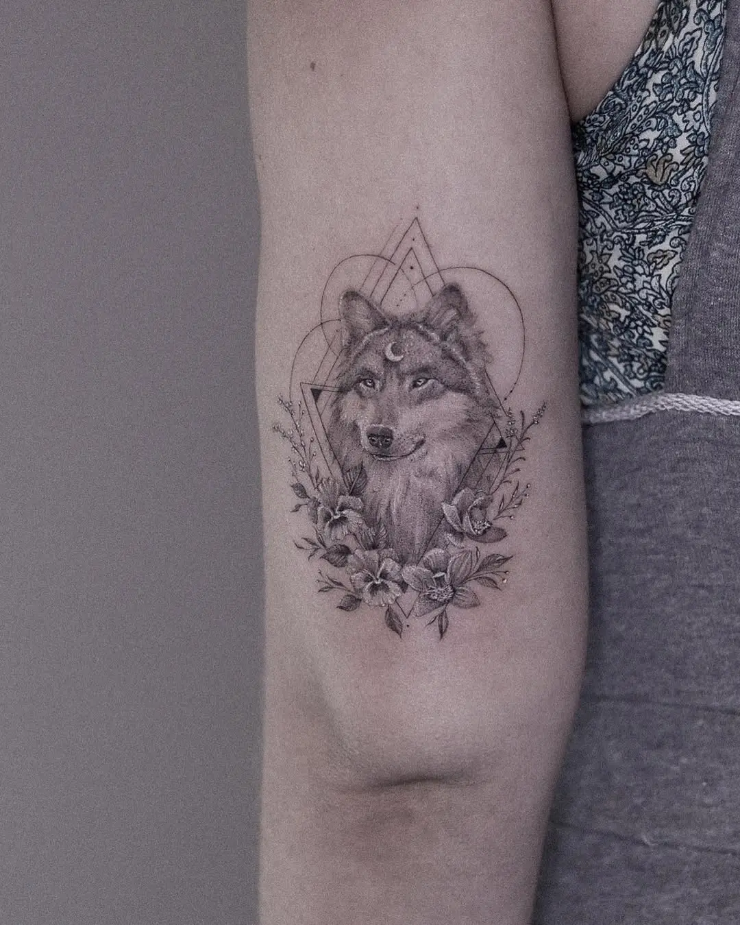 Stunning wolf tattoo with floral elements