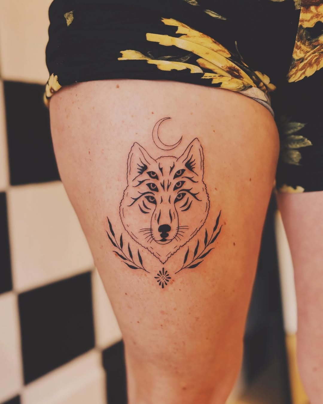 Intricate wolf tattoo with moon and floral elements