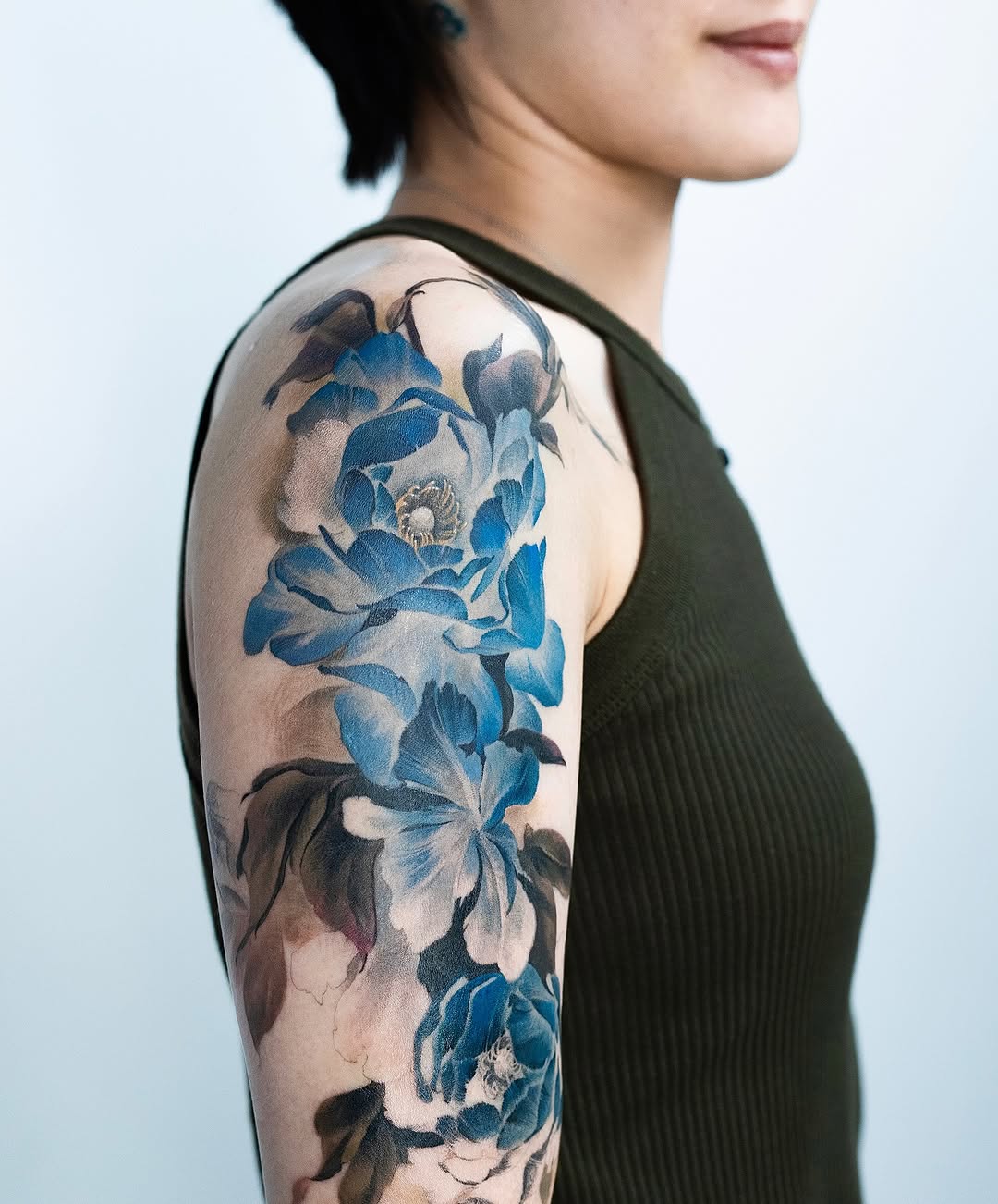 Elegant floral sleeve tattoo in blue hues