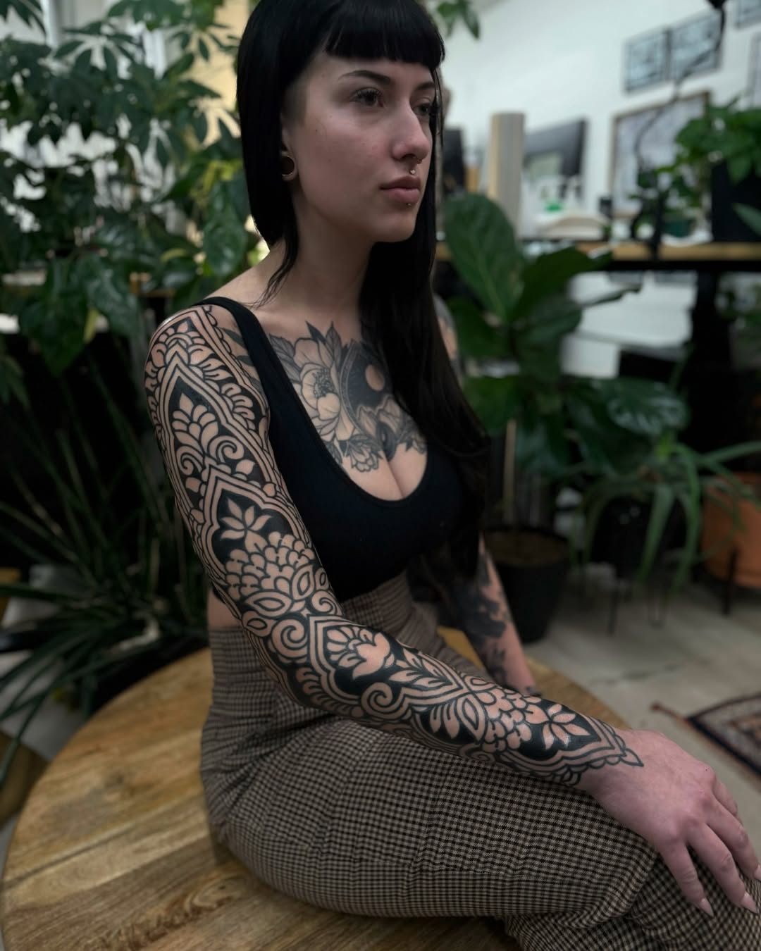 Intricate blackwork sleeve tattoo on a woman