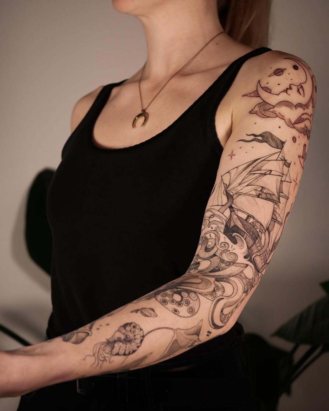 Intricate sailing ship and floral sleeve tattoo