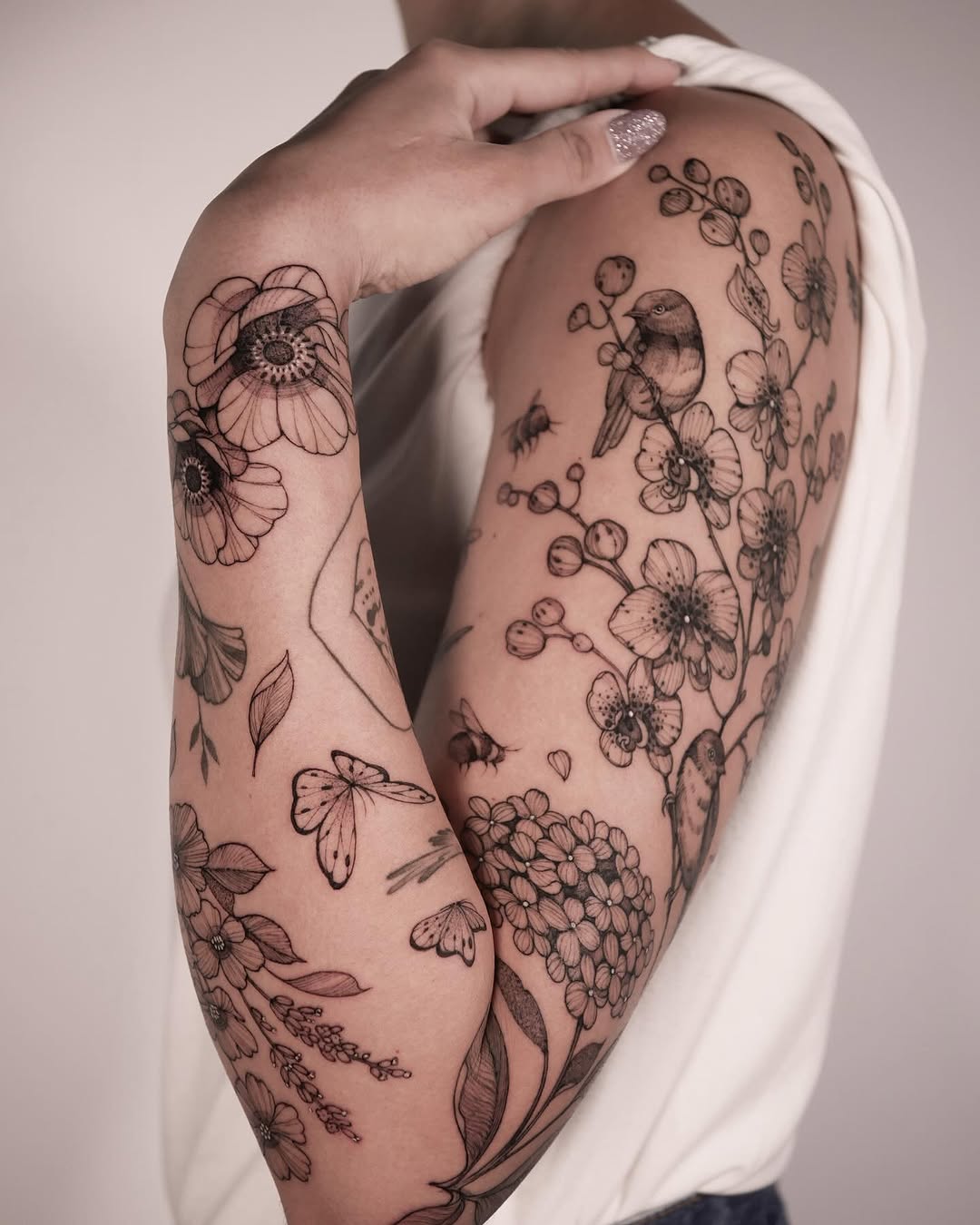 Elegant floral and bird sleeve tattoo design