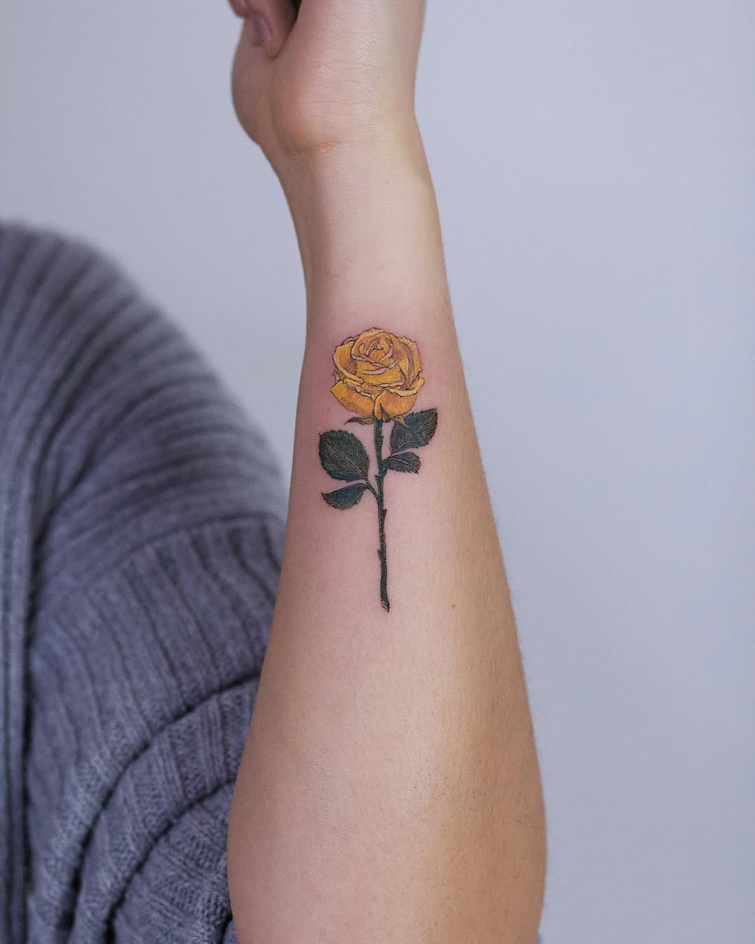 Stunning yellow rose tattoo on forearm.