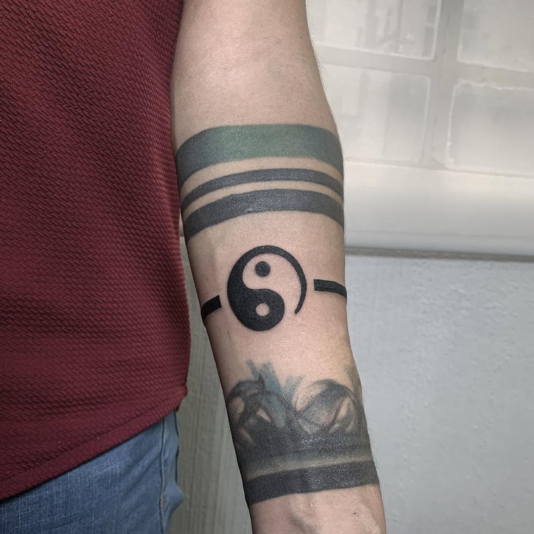 Stylish yin yang tattoo on a forearm