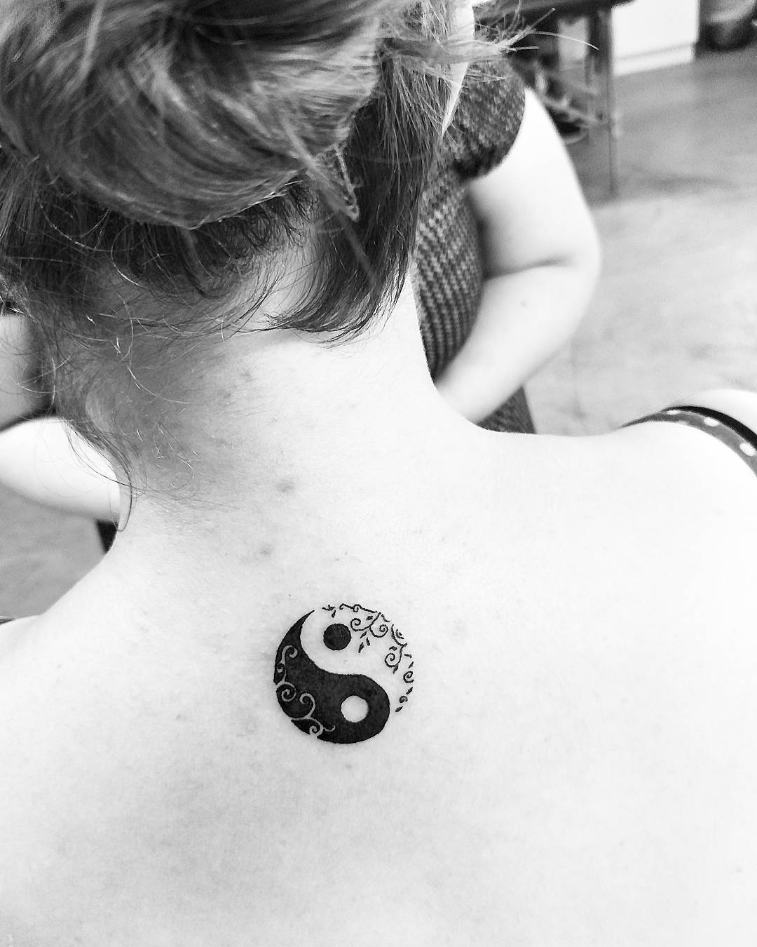 Elegant yin yang tattoo with floral accents