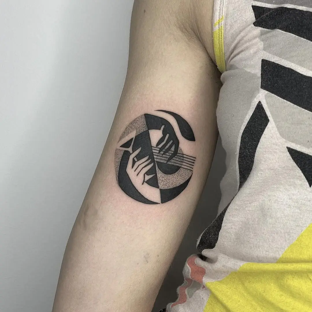 Unique yin yang tattoo featuring hands and music