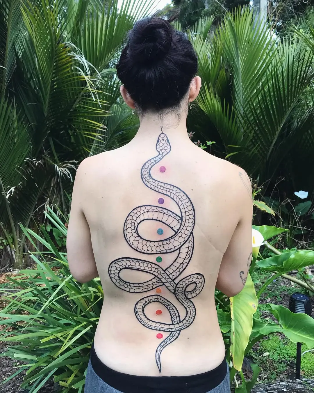 Elegant snake tattoo celebrating chakra alignment