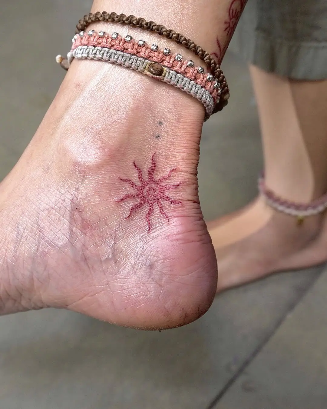 Elegant sun tattoo adorning the ankle
