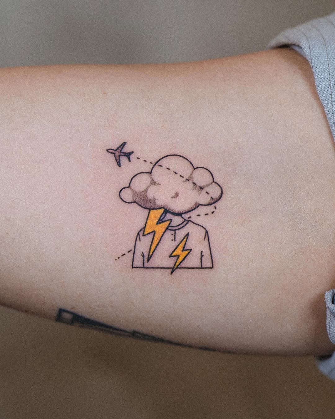 Whimsical airplane tattoo with a thunderstorm theme