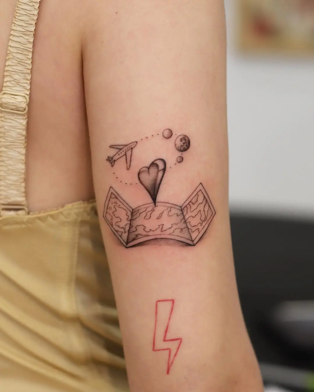 Whimsical airplane tattoo with heart and space theme