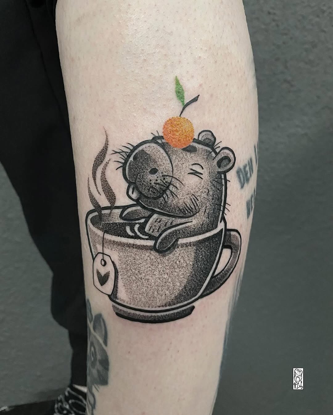 Charming capybara tattoo enjoying a cozy drink