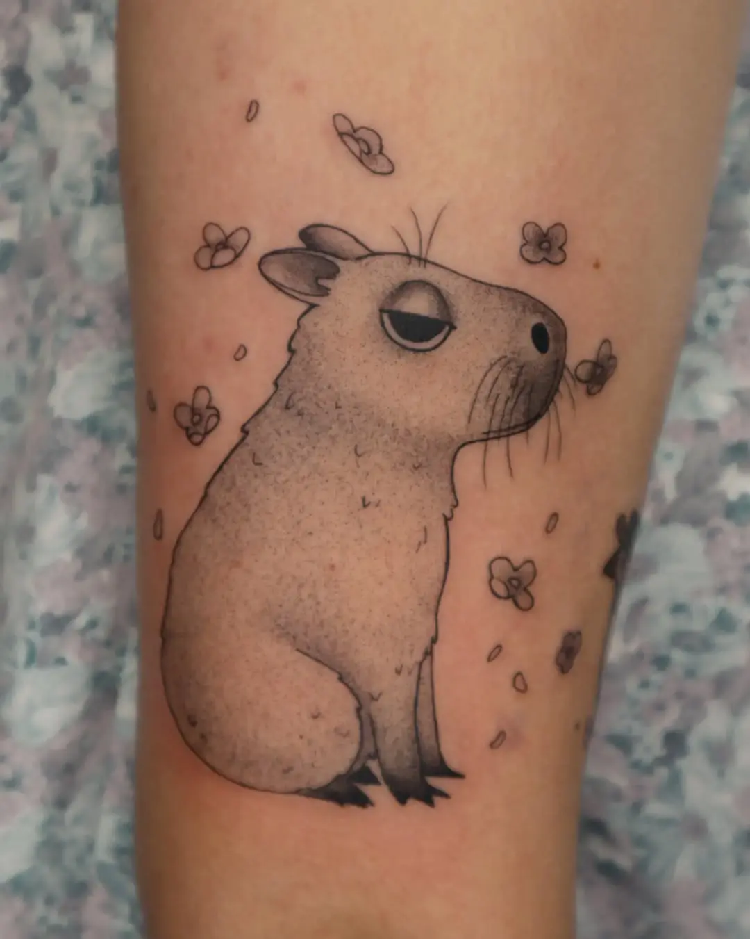 Adorable capybara tattoo with floral accents