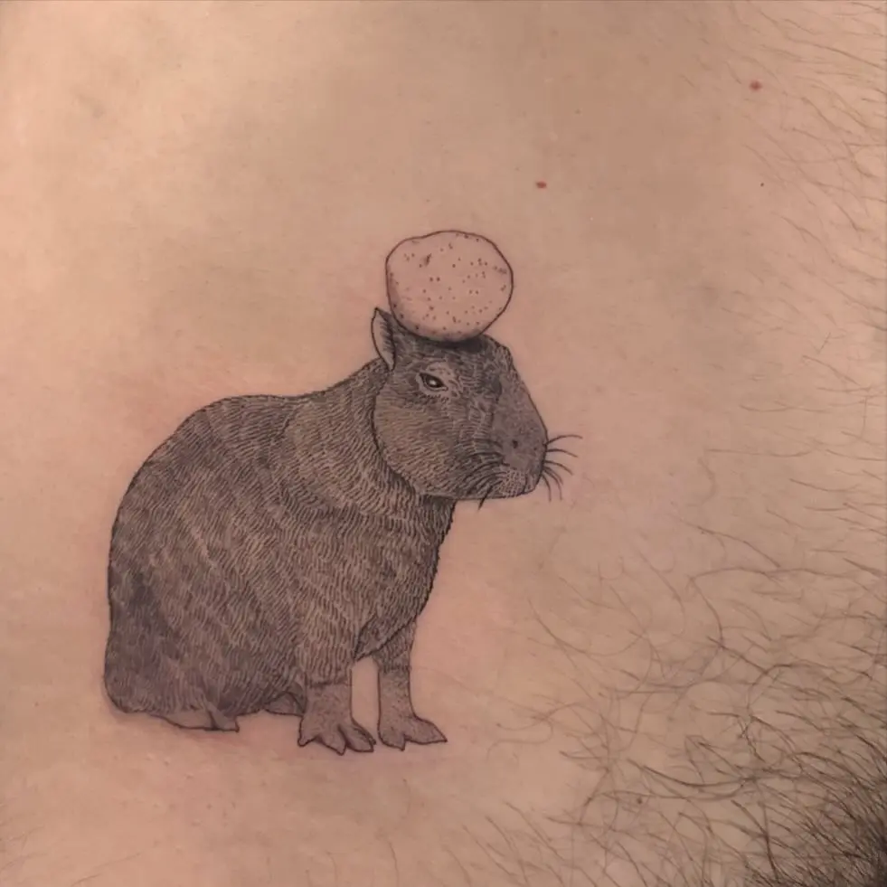 Quirky capybara tattoo with an egg on top