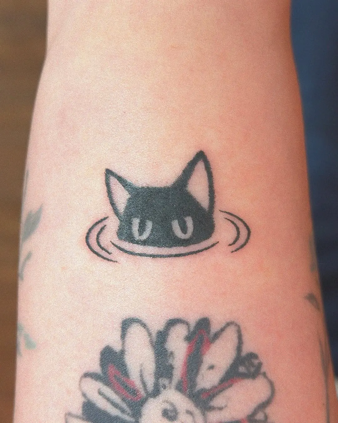 Charming black cat peeking above water