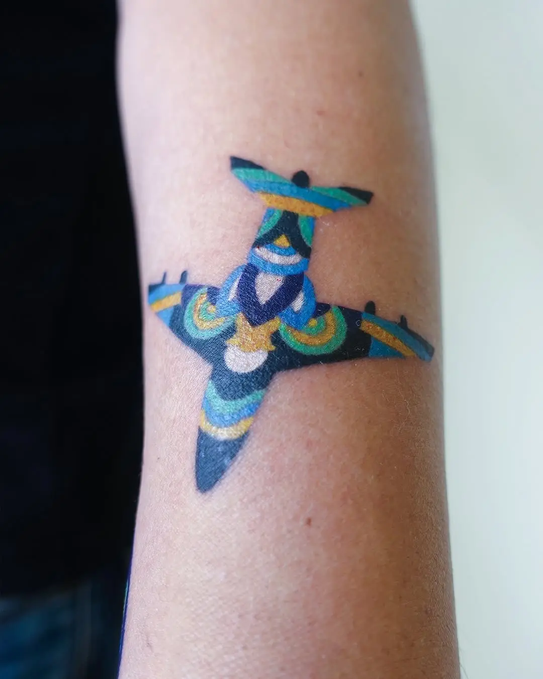 Vibrant airplane tattoo showcasing artistic flair