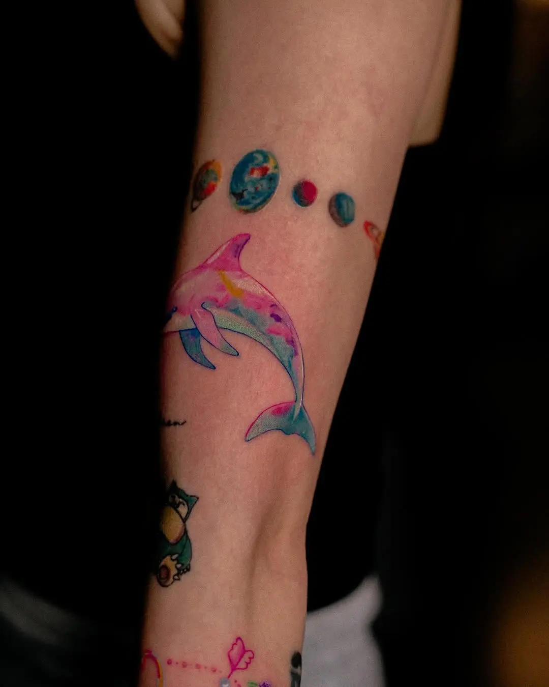 Whimsical dolphin tattoo with planetary designs