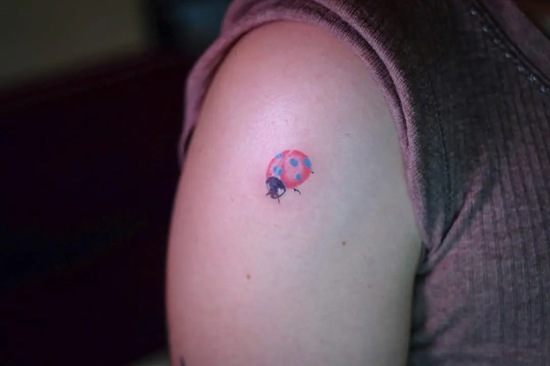 Charming ladybug tattoo on the upper arm