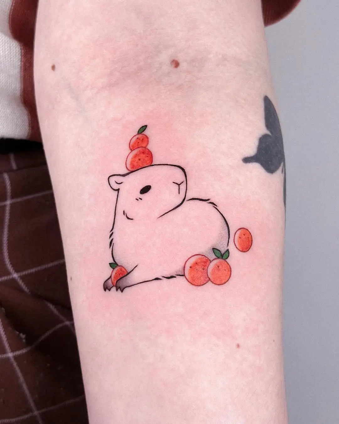 Charming capybara tattoo with a fruity twist