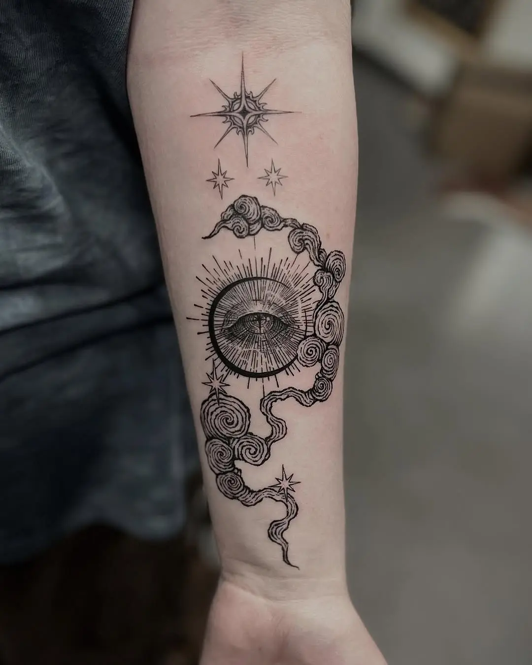 A celestial forearm tattoo of sun and moon