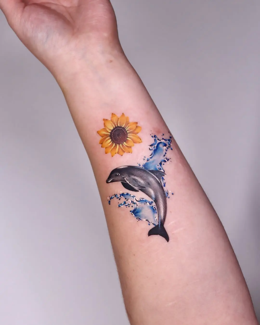 A vibrant dolphin with a sunflower tattoo