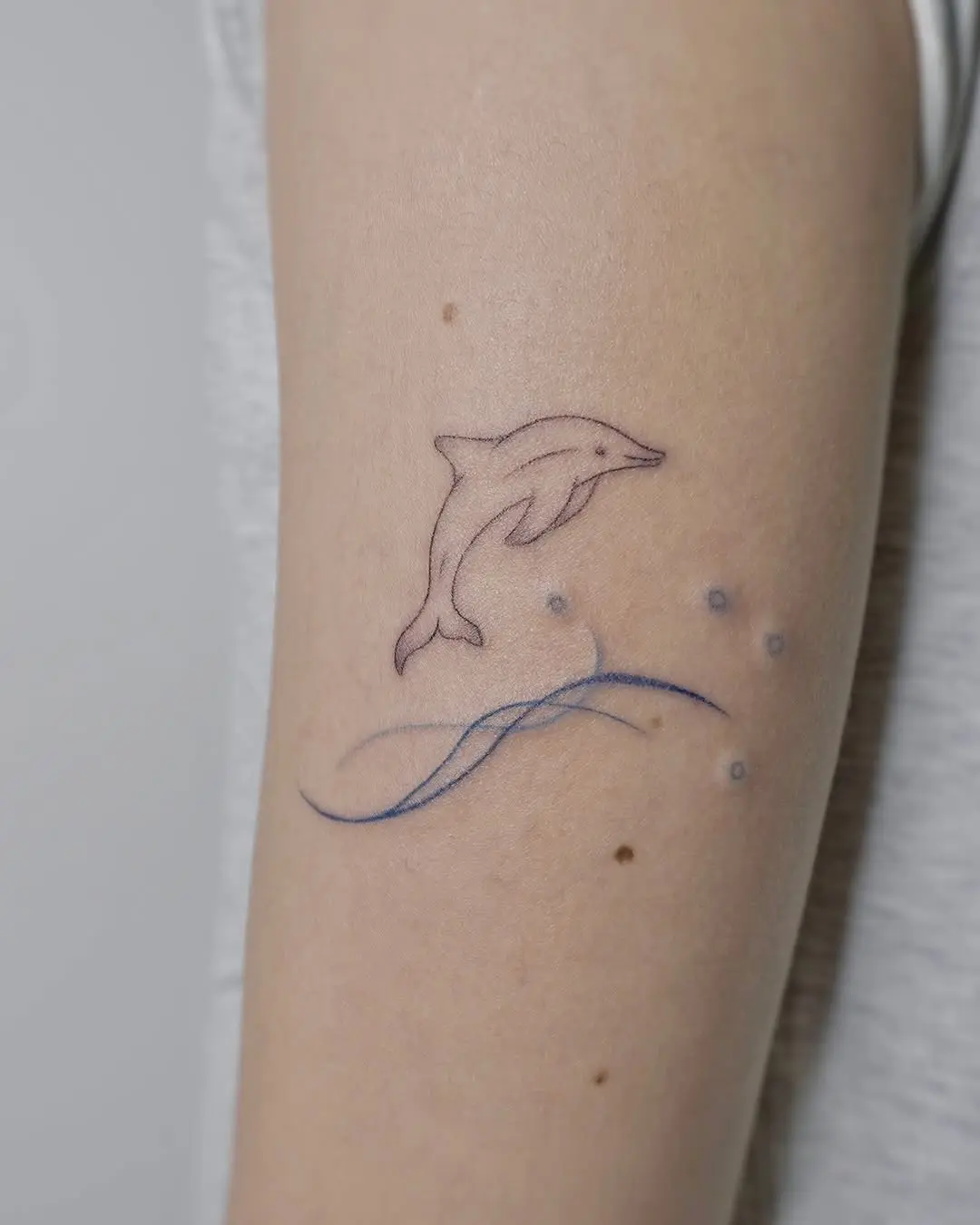 Elegant dolphin tattoo with flowing waves