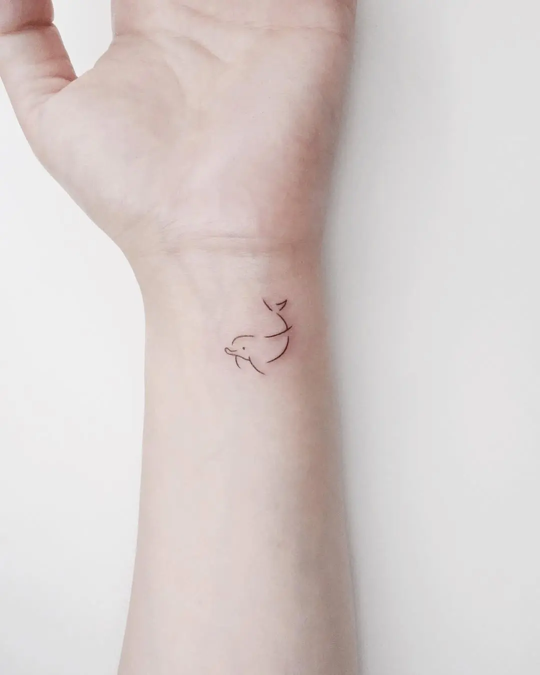 Minimalist Dolphin Tattoo on the Wrist