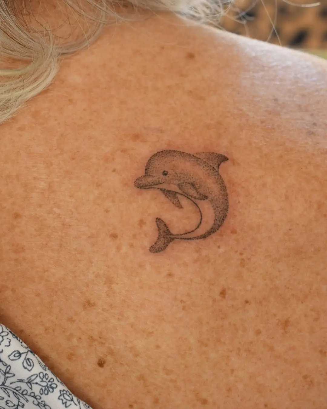 Charming dolphin tattoo on a woman's back
